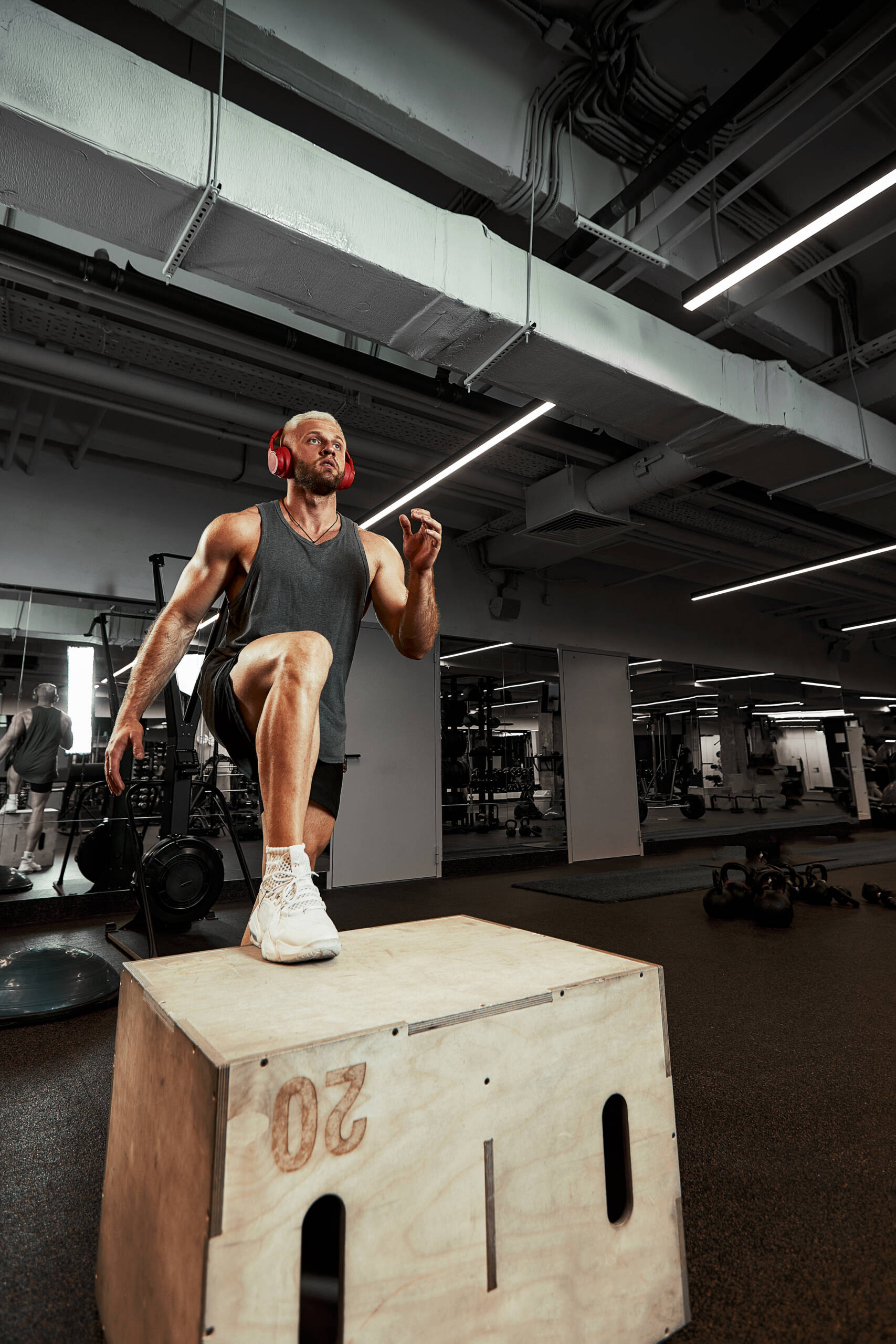 muscular men using the platform for his legs scaled